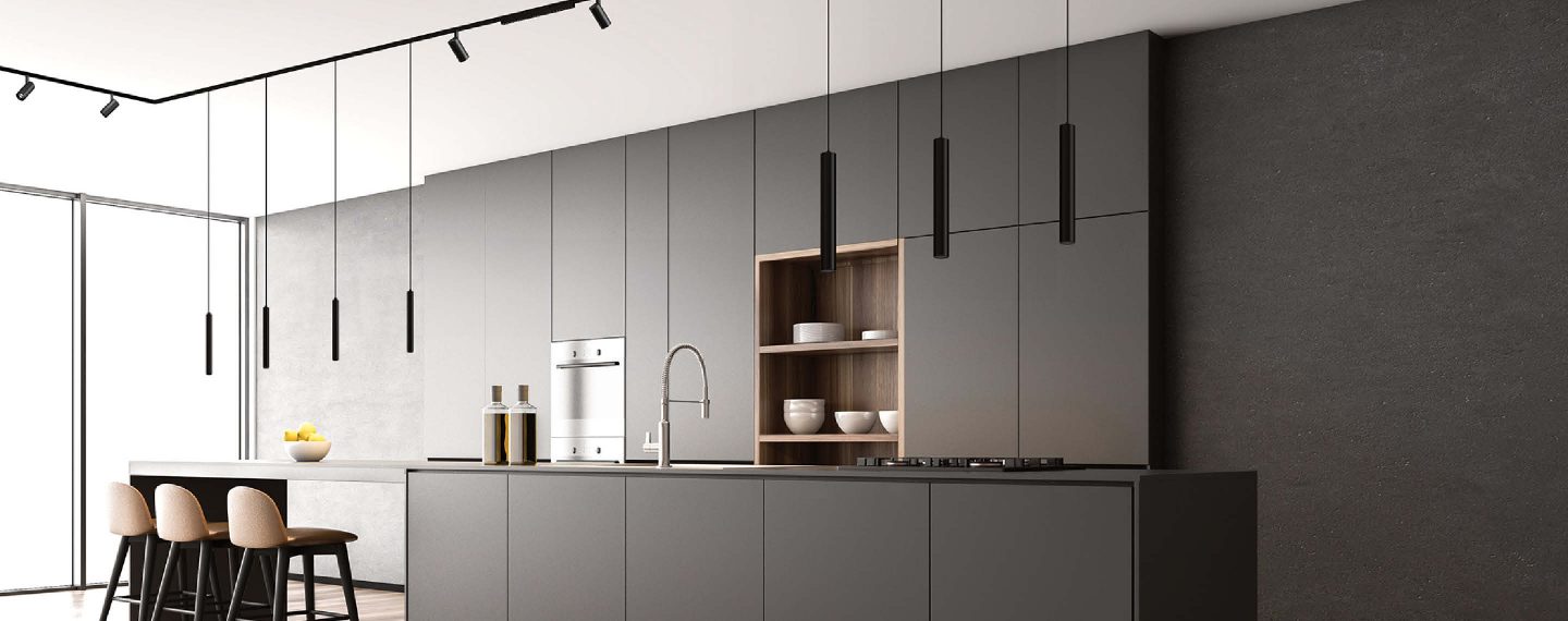 Moderne Designküche mit minimalistischer Linienführung und integriertem Stromschienensystem: Die filigranen Pendelleuchten sind flexibel positionierbar und sorgen für gezielte, blendfreie Ausleuchtung der Arbeitsbereiche – funktional, stilvoll und technisch durchdacht