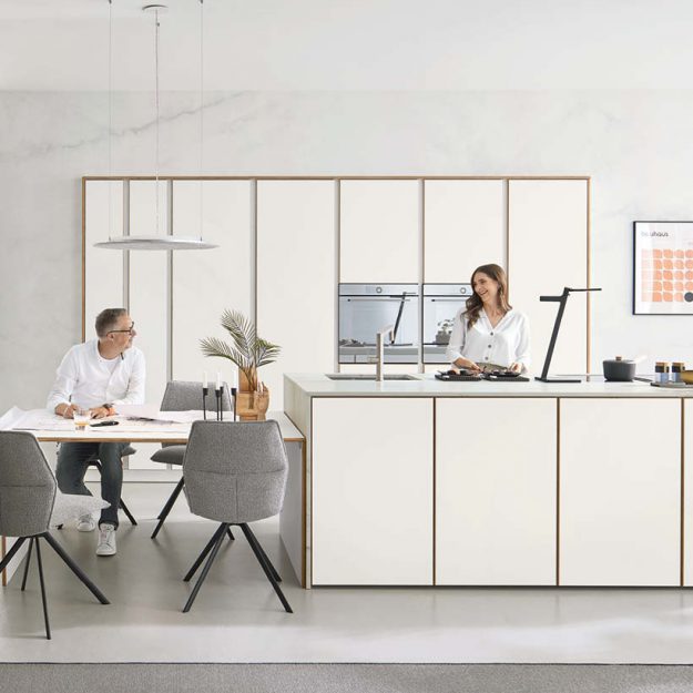 Minimalistische Designküche in Weiß mit klaren Linien, integrierter Kochinsel und offenem Essbereich für modernes Wohnen