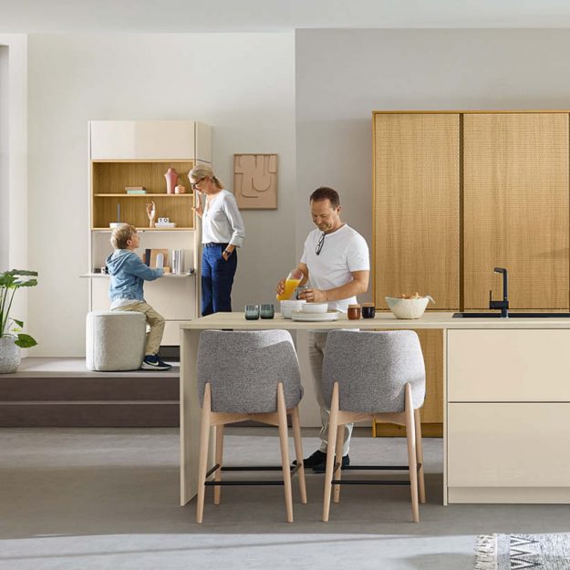 Wohnliche Familienküche in warmen Naturtönen mit integrierter Sitzlösung und funktionalen Stauraumkonzepten für den Alltag