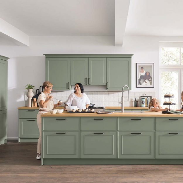 Moderne Landhausküche in sanftem Grün mit großzügiger Kochinsel – perfekt für den Familienalltag und gemeinsames Kochen