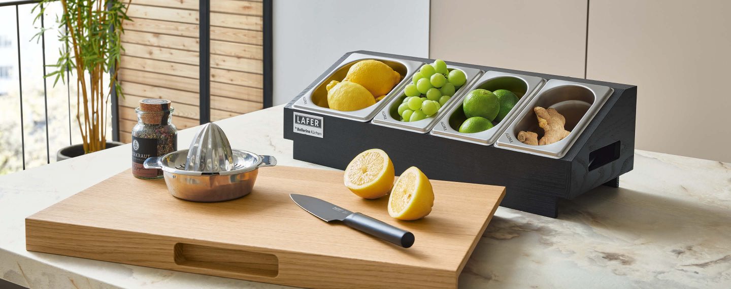 Alt-Text: Küchenmöbel von Ballerina im Küchenstudio Bodensee Küchen Markdorf mit Schneidebrett, Zitruspresse und Zutatenbehältern auf Arbeitsfläche