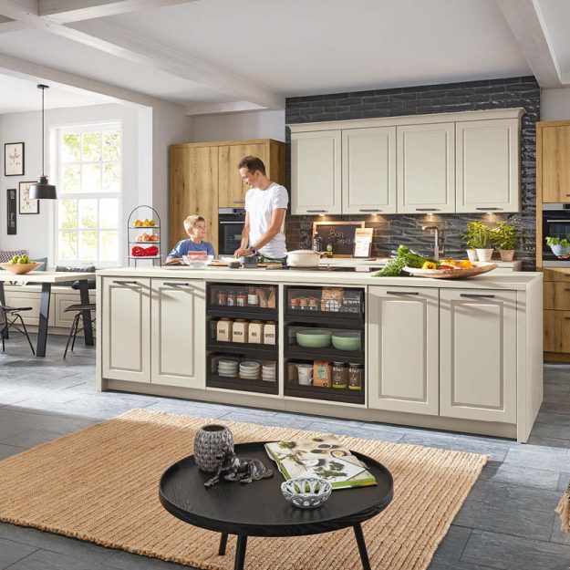 Gemütliche Landhausküche in hellen Naturtönen mit offenen Stauraumlösungen und großzügiger Insel – ideal für das gemeinsame Leben und Kochen